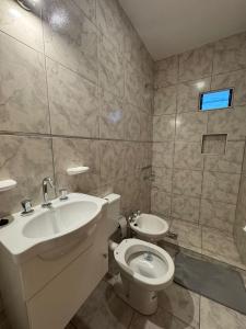 een badkamer met een wastafel en een toilet bij Temporal Colonia Caroya in Colonia Caroya +4 foto's