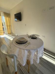 een witte tafel met borden en wijnglazen erop bij Temporal Colonia Caroya in Colonia Caroya