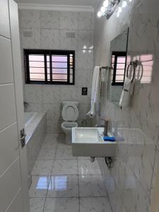 a white bathroom with a sink and a toilet at MY Home Apartments in Lusaka +22 photos
