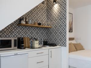 a kitchen with white cabinets and a black and white wall at Alvor Serene House I in Alvor