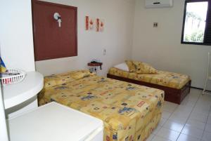a bedroom with two beds and a window at San Felipe Hotel in Juazeiro do Norte