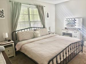 a bedroom with a large bed and a window at King Suite - Half Bath - Gym - Game Room - Hot Tub in Ellenwood