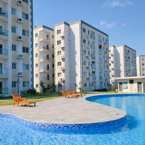 a pool with benches in front of some buildings at LuxDomus in Tema