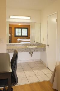 a bathroom with a sink and a bed at Casa Blanca Hotel - Azusa, Los Angeles in Azusa