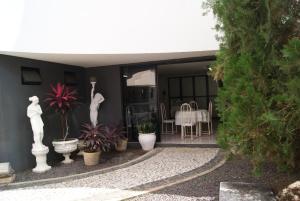 Casa con patio con mesa y algunas plantas en San Felipe Hotel en Juazeiro do Norte