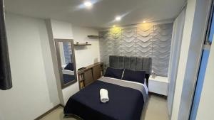 马尼萨莱斯Hermoso apartamento en Manizales的一间带一张床和浴缸的小卧室