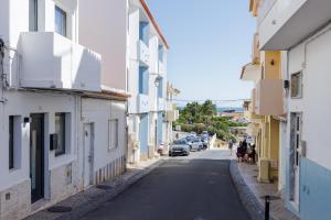 a narrow street with white and blue buildings at Alvor Serene House I in Alvor