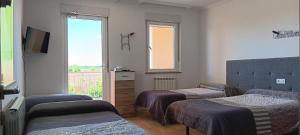a room with three beds and a tv and a window at CASA MIGUEL y SALLY in Villanueva de las Manzanas +41 photos