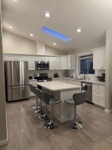 a kitchen with a large island with chairs in it at Spacious 5BR Walk to Wild Waves! in Federal Way