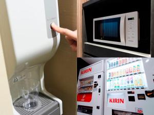 a refrigerator with a microwave and a hand pointing at it at APA Hotel Tonami Ekimae in Tonami