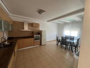 a kitchen and dining room with a table and chairs at Vila Oron in Vlorë