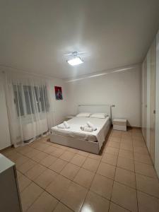 a bedroom with a bed and a tiled floor at Vila Oron in Vlorë