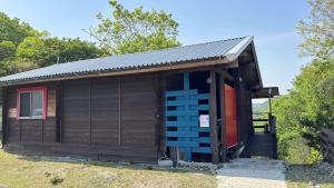 a small wooden cabin with a red door at Smith's island Hut in Hinase