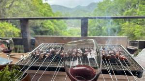a grill with a glass of wine and some food at Smith's island Hut in Hinase