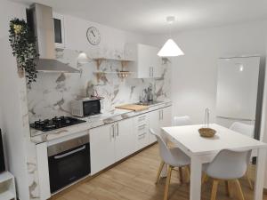 a white kitchen with a table and a white counter top at Piedras del Teide in Guía de Isora
