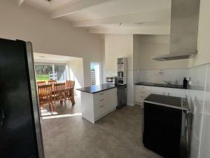 eine Küche mit weißen Schränken und einer schwarzen Arbeitsplatte in der Unterkunft Te Tihi Noho Shared Accommodation 