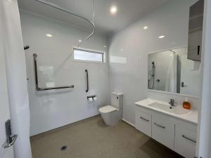 ein weißes Badezimmer mit Toilette und Waschbecken in der Unterkunft Te Tihi Noho Shared Accommodation 