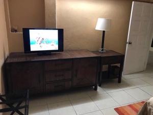 a television sitting on top of a wooden dresser at The Springs Estate in Corinthe