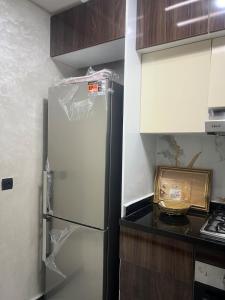 a kitchen with a refrigerator in a kitchen at Very nice modern air-conditioned apartment in Fez in Fès