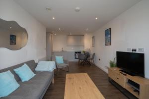 a living room with a couch and a flat screen tv at Luxury 2 Bed Penthouse Manchester Large Balcony in Manchester