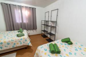 Habitación con 2 camas y estante para libros en Casa Veredas Campos do Jordão, en Campos do Jordão