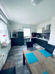 a kitchen with a wooden table and blue mats at Ferienhaus Bailey in Laupheim