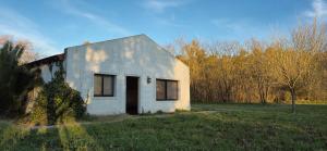 a small white house sitting in a field at La Casita del Monte in San Miguel del Monte