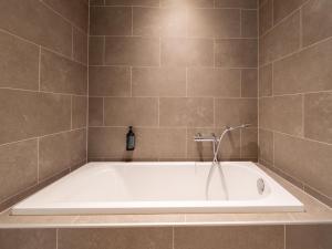 a bath tub with a shower in a bathroom at Duplex by Fouage Pond with Stunning Views in Antoing +31 photos