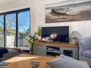 Una sala de estar con un televisor de pantalla plana sobre una mesa. en Inglewood Retreat, en Saint Lawrence