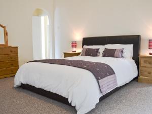 a bedroom with a large bed with white sheets and pillows at Blackmoor Farmhouse in Stepaside +20 photos