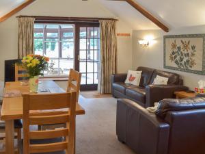een woonkamer met een tafel en een eetkamer bij Garden Cottage - Cp28 in Halwell