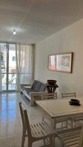 a living room with a couch and a table and chairs at Apartamento refúgio tropical in Arraial do Cabo