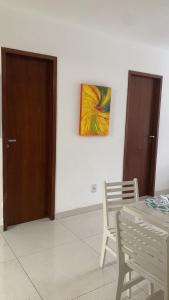 a room with a table and a painting on the wall at Apartamento refúgio tropical in Arraial do Cabo +4 photos