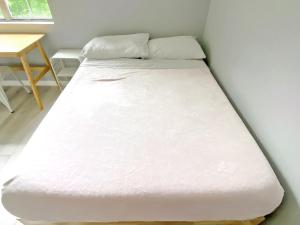 a bed in a room with a white mattress at Corporate Retreat - Stylish 2BR Condo with Pool, Balcony & Fast Wi-Fi, Minutes from Downtown Wilmington in Wilmington +26 photos