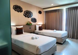 Una cama o camas en una habitación de Chaba Inn Srinakarin 23 fotos más