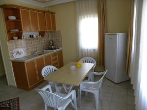 a kitchen with a table and chairs and a refrigerator at Ada Apart Hotel in Dalyan