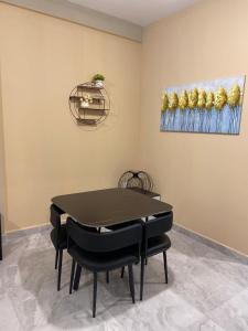 a dining room with a black table and black chairs at Cosy, accessible, comme et sécure in Kinshasa