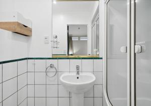 a white bathroom with a sink and a shower at Spacious, 2 Bed, 2 Bath Central City Retreat in Wellington +12 photos