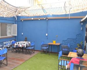 a man sitting at a table in front of a blue wall at Hostel Urqu Ñan in Mendoza