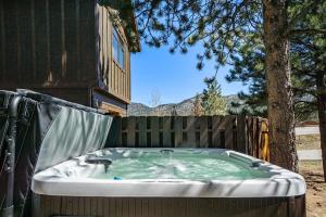 d'un bain à remous dans un jardin avec un arbre. dans l'établissement Estes Park Luxury Family Retreat, à Estes Park