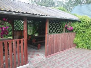 a house with a wooden fence and flowers at Järve Holiday Village in Kodavere