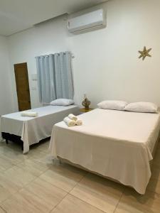 two beds sitting next to each other in a room at Casa da Andrea 02 in Barreirinhas