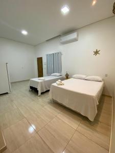 a bedroom with two beds in a room at Casa da Andrea 02 in Barreirinhas +2 photos