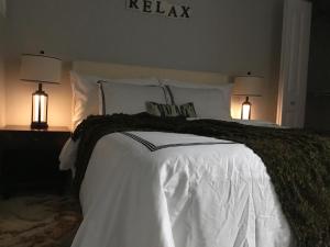 a bedroom with a white bed with two lamps at Almost Heaven - Cozy 2BDRM APT near Heritage Park,Spruce Meadows & Banff-SW Calgary in Calgary