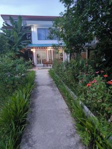 a pathway leading to a house with flowers and plants at Dok Champa Resort in Vang Vieng