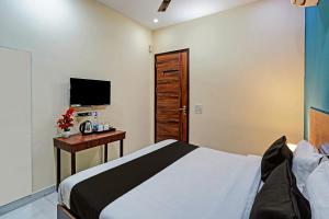 une chambre avec un lit, un bureau et une télévision dans l'établissement Royal Hotel, à Gurgaon 22 autres photos