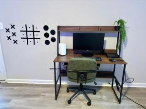 a desk with a computer monitor and a chair at Vintage Queen Suite - 7 mins From ATL Airport in Riverdale