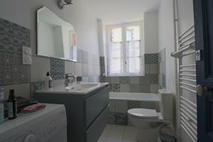 un bagno con lavandino, WC e finestra di Le Gentiane - Villa Chanterive a La Bourboule Altre 21 foto
