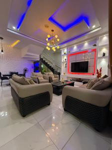 a living room with couches and a flat screen tv at Beautifully furnished 4 Bedroom Duplex in Lekki