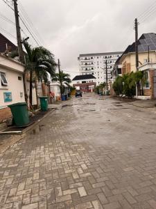 an empty street with palm trees and buildings at Beautifully furnished 4 Bedroom Duplex in Lekki